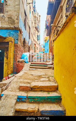The narrow hilly backstreet in shabby neighborhood with colorful stairs and line of old residential houses, Cairo, Egypt Stock Photo