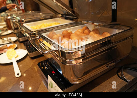 Chafing dish with eggs on table in dining room Stock Photo