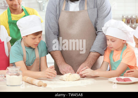 Group of children and teacher in kitchen during cooking classes Stock Photo