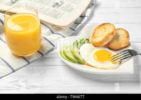 Delicious over easy egg with toasts and avocado on kitchen table Stock Photo