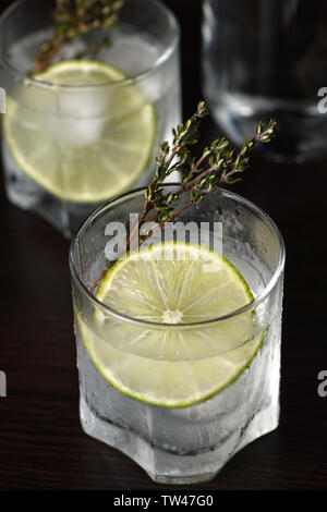 Gin and tonic with a slice of lime and sprigs of thyme Stock Photo