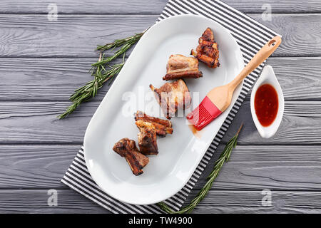 Plate with delicious pork ribs on wooden table Stock Photo