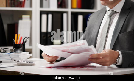 Businessman working and calculating, reads and writes reports. Office employee, table closeup. Business financial accounting concept. Stock Photo