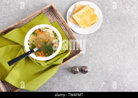 Plate with homemade chicken soup on wicker tray Stock Photo
