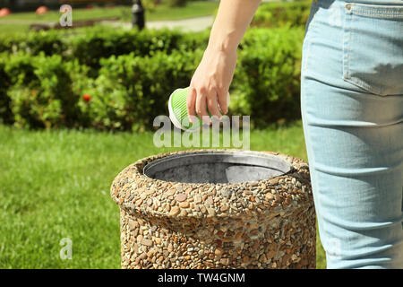 Young woman throwing paper cup in litter bin, close up Stock Photo - Alamy