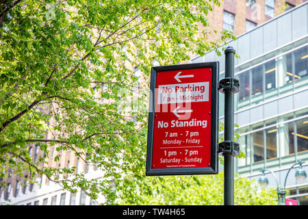 New York, USA. May 2, 2019. No parking, no standing red color sign on metal pole, blur office buildings background. Manhattan downtown Stock Photo