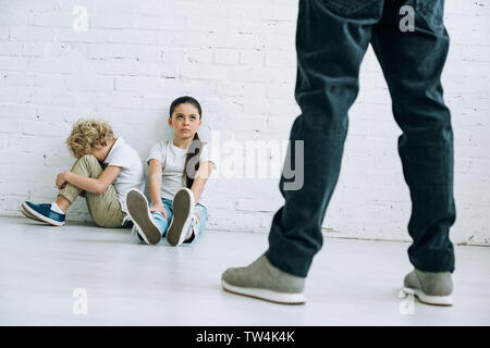 Abused Young Boy With Strap Marks On His Bare Back From A Sound Beating  With A Black Belt Lying Beside Him Sitting Huddled Up On The Floor Stock  Photo, Picture and Royalty