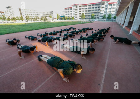 August 8, 2018 is National Fitness Day. On the morning of the same day, in the Stadium of the Fourth Middle School Volunteer Education Department, Xiangcheng District, Xiangyang City, Hubei Province, officers and men of the fire detachment used morning exercise time to carry out basic physical training and strength training such as 5000-meter running, 100-meter running, push-ups, sit-ups, pressing legs and so on. Stock Photo