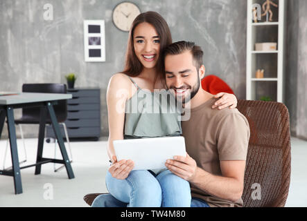 Young couple searching information using tablet at home Stock Photo