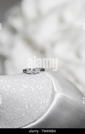 close up of brides engagement ring sitting on the sparkly heel of her shoe on her wedding day, no people. Stock Photo