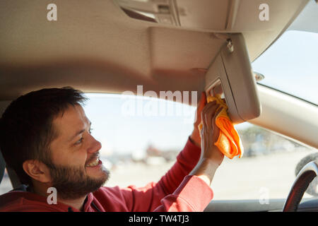 Photo on side of male with orange rag washing mirror of car,close up Stock Photo