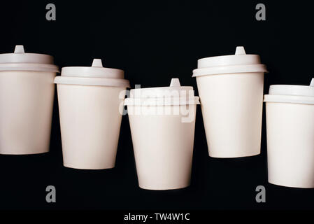 Five paper cups for coffee or tea isolated on black background. Stock Photo
