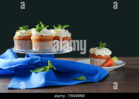 Glass stand with delicious carrot cupcakes on table Stock Photo