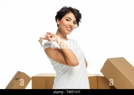 low angle view of happy latin woman holding key isolated on white Stock Photo