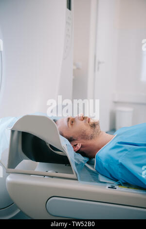 handsome man lying on ct scanner bed during tomography diagnostics in hospital Stock Photo