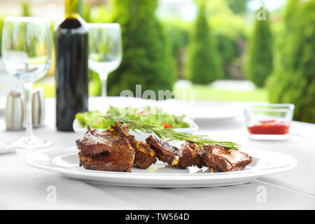 Delicious ribs served for dinner on table Stock Photo
