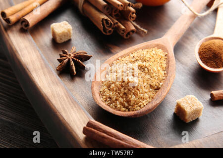 Cinnamon sugar in wooden spoon on serving board Stock Photo