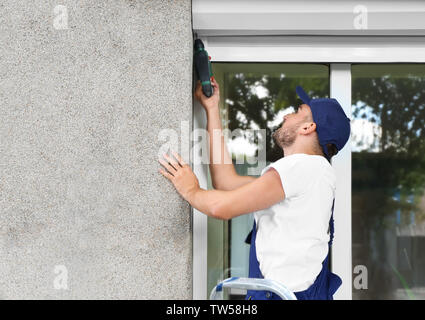 Man installing roller shutter on window Stock Photo