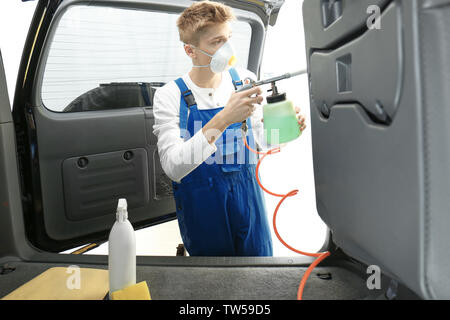 Young man cleaning car salon in body shop Stock Photo