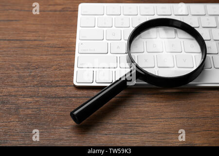 Magnifying glass on keyboard. Internet search concept Stock Photo