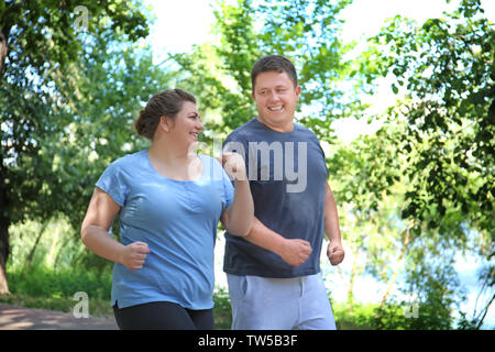 Overweight couple running in green park Stock Photo