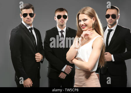 Famous celebrity with bodyguards on grey background Stock Photo