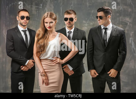 Famous celebrity with bodyguards on grunge background Stock Photo