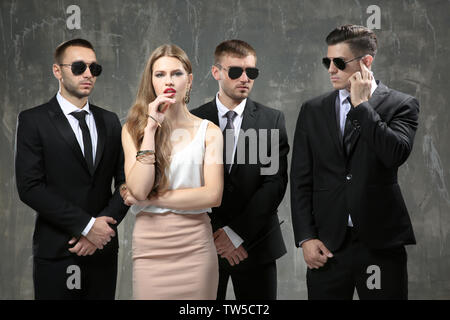 Famous celebrity with bodyguards on grunge background Stock Photo