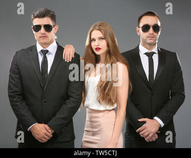 Famous celebrity with bodyguards on grey background Stock Photo