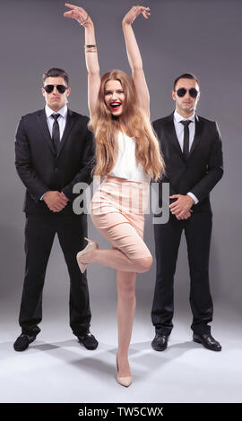 Famous celebrity with bodyguards on grey background Stock Photo