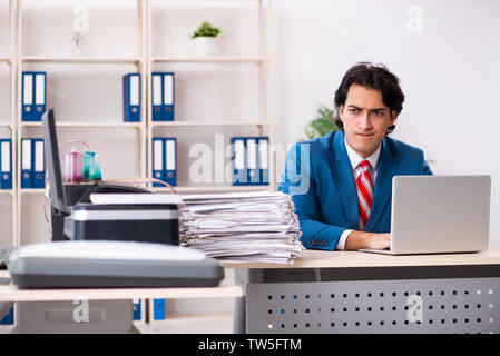 Young employee making copies at copying machine Stock Photo