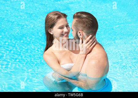 Happy couple hugging in swimming pool Stock Photo