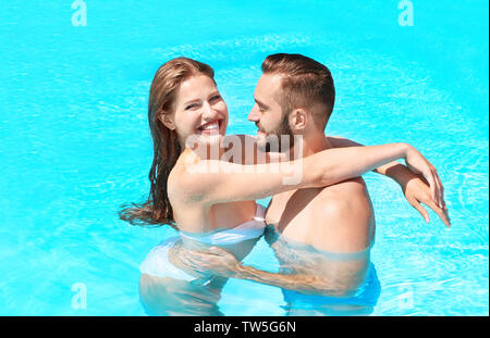 Happy couple hugging in swimming pool Stock Photo