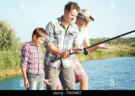 Family fishing on pond together Stock Photo