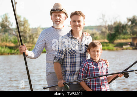 Family fishing on pond together Stock Photo