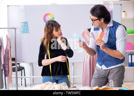 Young male tailor teaching female student Stock Photo
