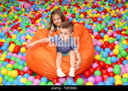Cute children playing among plastic balls Stock Photo