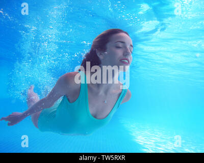 Beautiful young woman swimming under water in pool Stock Photo - Alamy
