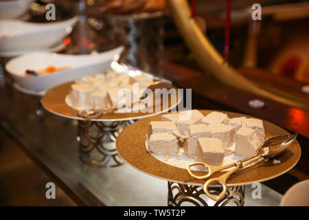 Plates with different kinds of desserts on table at buffet Stock Photo