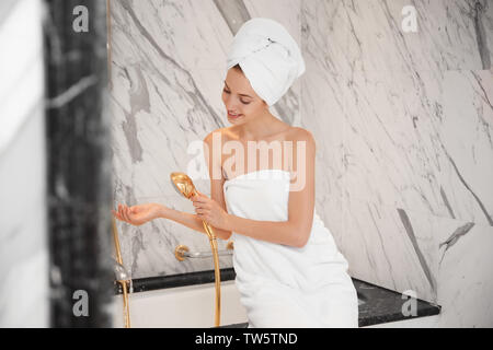 Beautiful young woman going to take shower in bathroom Stock Photo