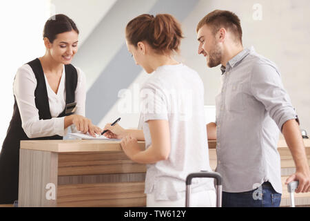 Young couple near reception desk in hotel Stock Photo