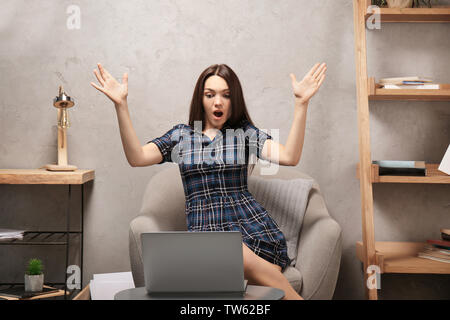 Young woman with laptop at home Stock Photo