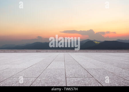 empty marble floor with green mountains at twilight Stock Photo