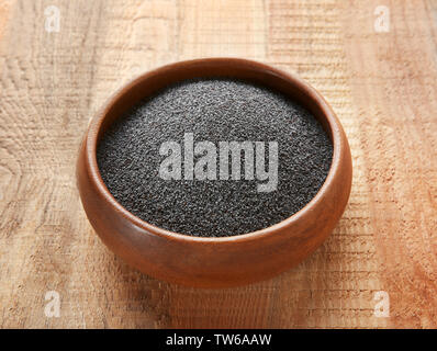 Ripe poppy seeds in bowl on wooden background Stock Photo