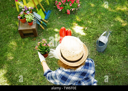 Woman taking care of plants in backyard Stock Photo