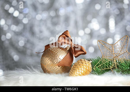 Beautiful composition with Christmas decorations and brunches of fir tree on soft plaid against blurred background Stock Photo