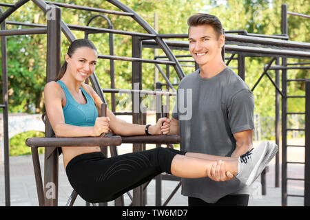 Young sporty couple doing exercise on playground Stock Photo