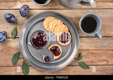 Tray with bowl of plum jam and cookies on wooden table Stock Photo