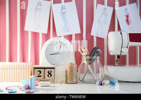Sewing accessories and machine on table in workshop Stock Photo