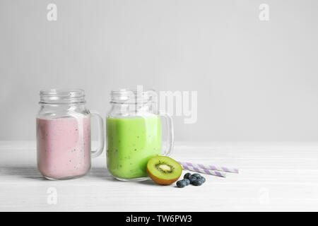 Mason jars with fresh protein shakes on table against white background Stock Photo